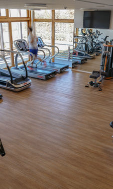 Heller Fitnessraum mit vielen unterschiedlichen Geräten im Fitnessstudio des Wellnesshotels in Bayern