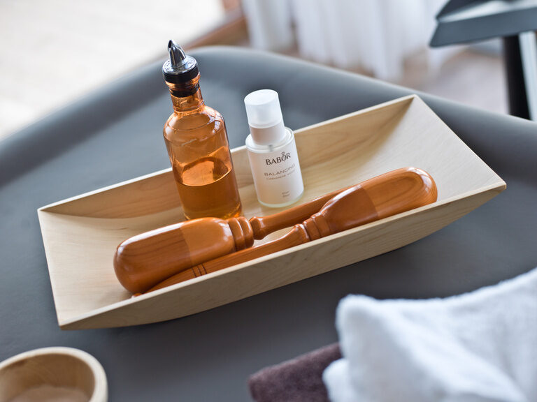 Massageöl liegt in einer Holzschale im Beauty & Wellnessbereich des Birkenhofs