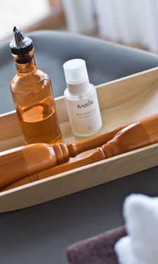 Massageöl liegt in einer Holzschale im Beauty & Wellnessbereich des Birkenhofs in Bayern