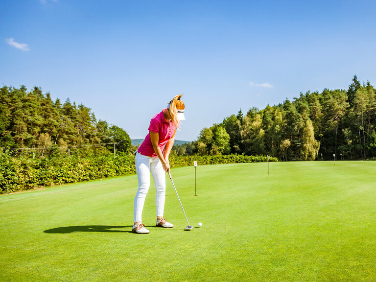 Frau spielt Golf auf großzügige Golfplatz