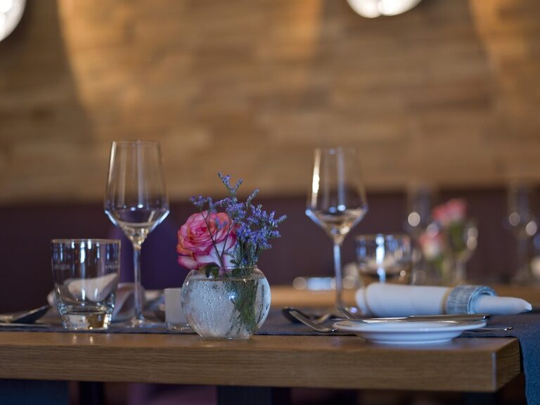Gedeckter Tisch mit Blumendekoration im Restaurant Landart